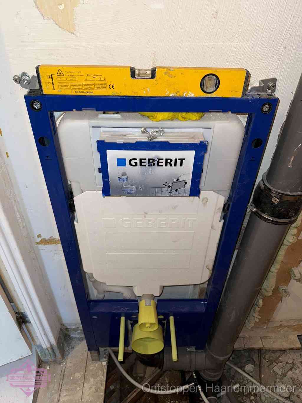 Een Geberit inbouwreservoir met frame voor een hangtoilet tegen de wand, met de afvoerbocht naar de vloer, kenmerkend voor een verstopt hangtoilet in Haarlemmermeer