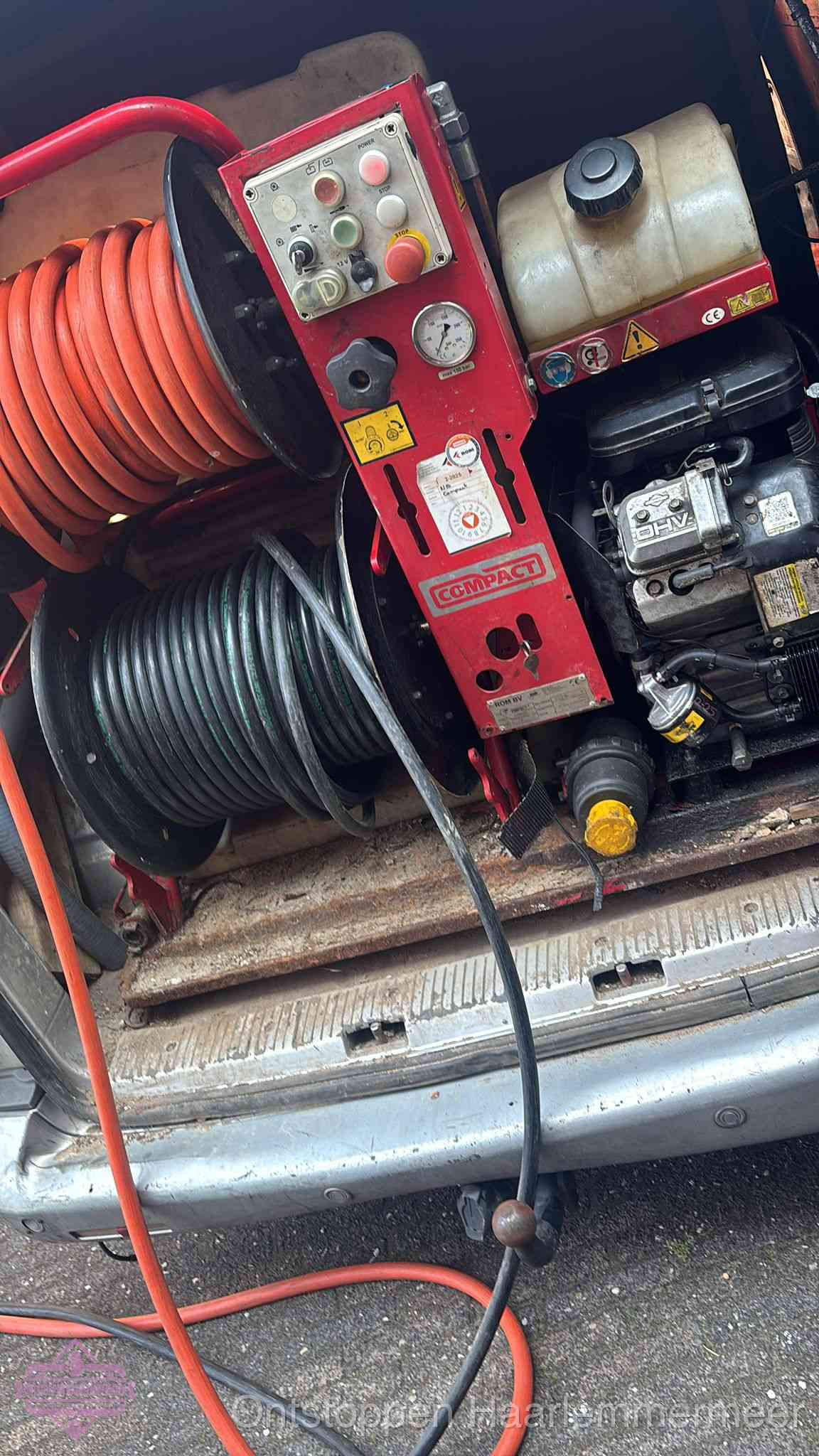 Een rood hogedruk-rioolreinigingstoestel met slangen in de laadbak van de bedrijfsbus, apparatuur voor een hardnekkige wc-verstopping in Haarlemmermeer