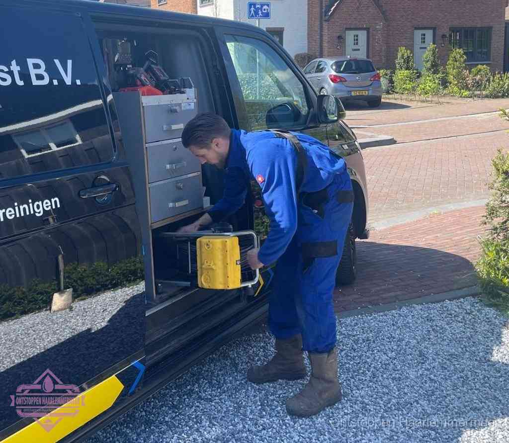 Een monteur pakt apparatuur uit de bedrijfsbus voor service aan huis, het moment om een professional in te schakelen voor een verstopte wc in Haarlemmermeer