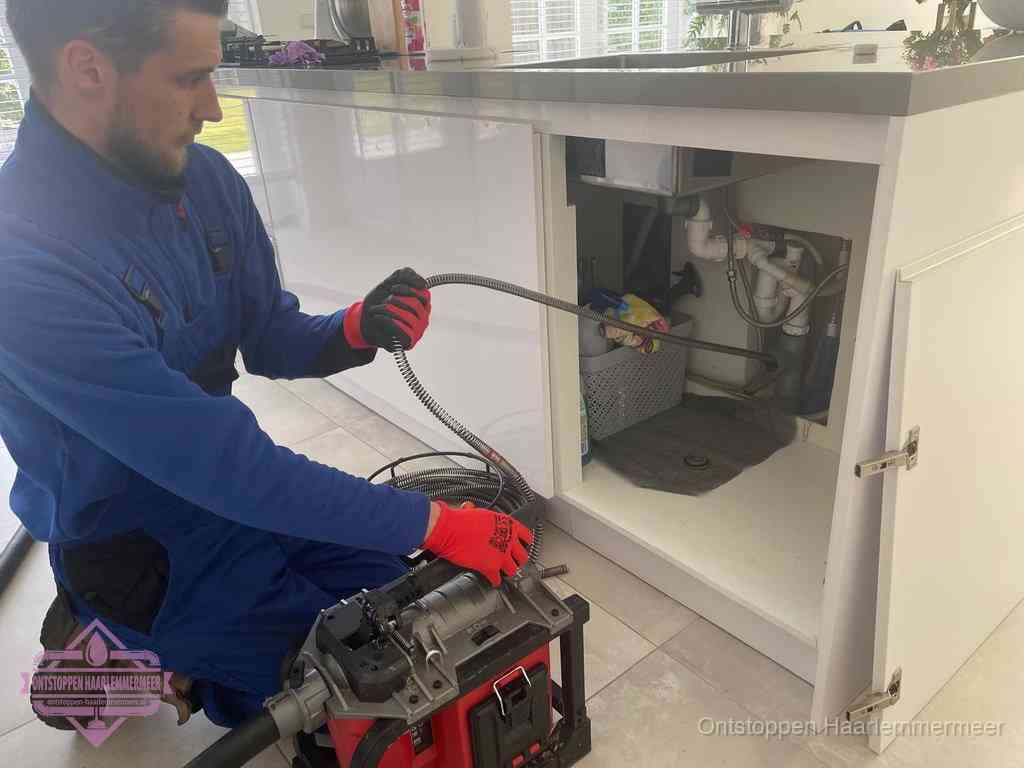 Een monteur reinigt de keukenafvoer grondig met een veermachine om terugkerende gootsteenverstoppingen te voorkomen in Haarlemmermeer